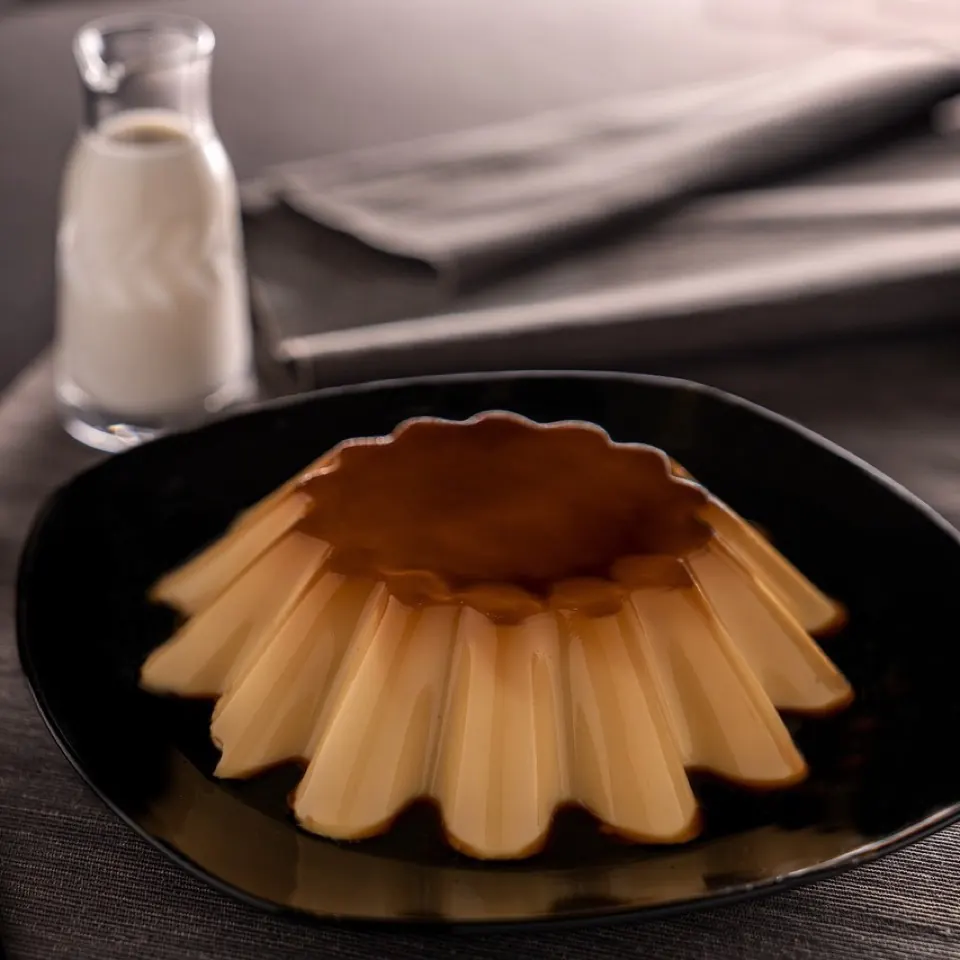 A fluted gula melaka custard on a dark plate